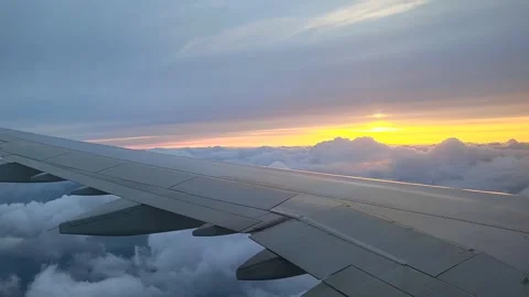 View from the window of the airplane to the beautiful cloudy sunset Stock Footage 311030101