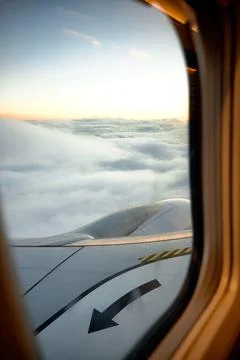 View from the window of an airplane with beautiful cloudy sky at sunrise. tra Stock Photos