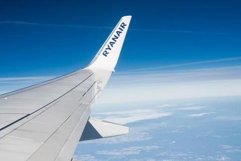 View from the window of an airplane on clouds with the wing of a Ryanair Stock Photos