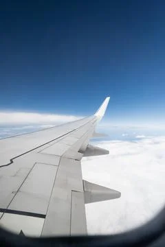 View from the window of an airplane in flight on clouds with the wing Stock Photos