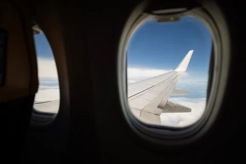 View from the window of an airplane in flight on clouds with the wing Stock Photos