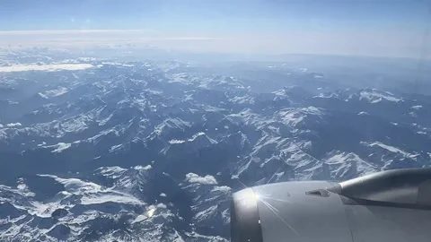 View from the window of an airplane flying over the Alps Stock Footage 313220449