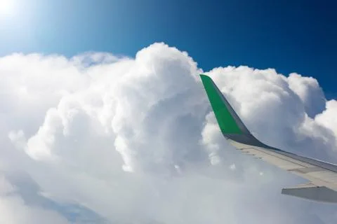 View from the window of an airplane, white clouds, blue sky, wing of an airplane 库存照片