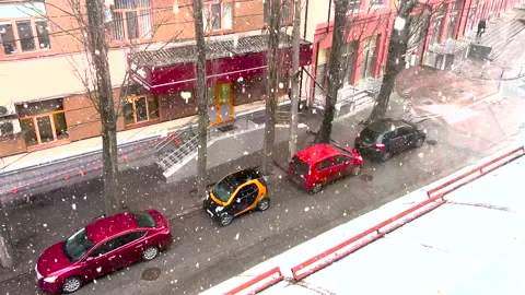 View from the window on a beautiful snowfall falling on cars parked near the Stock Footage 234926522