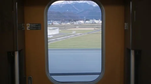 View to window on board at bullet high speed train's door with natural moun.. Stock Footage 316392577