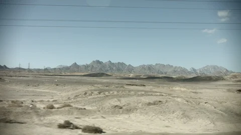 View from the window of a bus driving along a road in Egypt. Sandy desert landsc Stock Footage 122283234