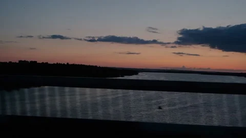 View from the window of the car on the river during sunset. The car drives over Stock Footage 211108976