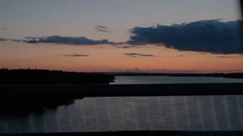 View from the window of the car on the river during sunset. Traveling by car Stock Footage 212426316