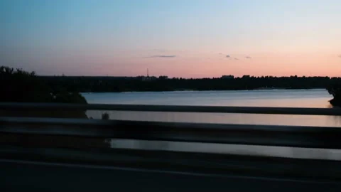 View from the window of the car on the river during sunset. The car drives over Stock Footage 217820904