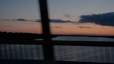 View from the window of the car on the river during sunset. The car drives over Stock Footage 217821994