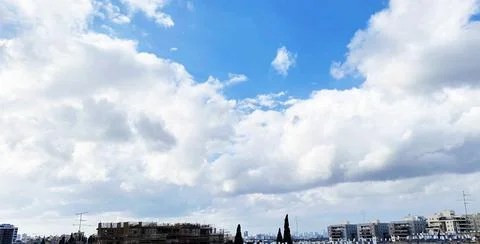 View from the window. City view over blue sky and white clouds 库存照片