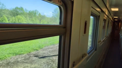 View from window of compartment car of passenger train. Train travels past Stockbeeldmateriaal 315365239