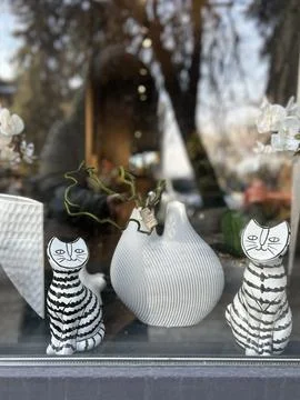 View of the window decorated with plaster figures of striped cats near a la.. Stock Photos