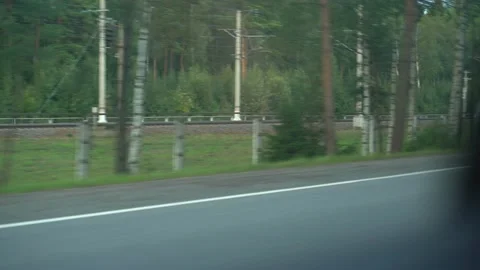 View from the window of the driving car. Passing cars passing by. A man shoots a Video stock 161244418