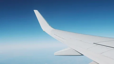 View from the window of a flying airplane on a blue sky and high mountains Stock Footage 118606633