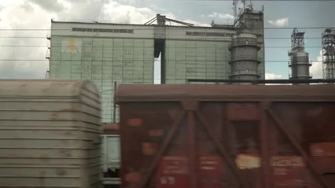 View from window of high-speed train on landscape of old rusty boxcars and steel Stock Footage 155998402