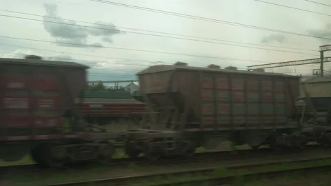View from window of high-speed train on landscape of old rusty boxcars and high Stock Footage 156024122