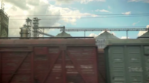 View from window of high-speed train on landscape of old rusty boxcars and steel Stock Footage 156366400