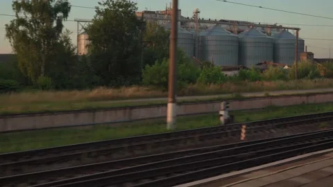 View from window of high-speed train on landscape of old rusty boxcars and steel Stock Footage 157563074