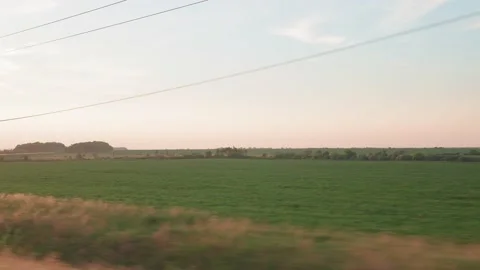 View from window of high-speed train on landscape of beautiful nature wild field Stock Footage 157836379