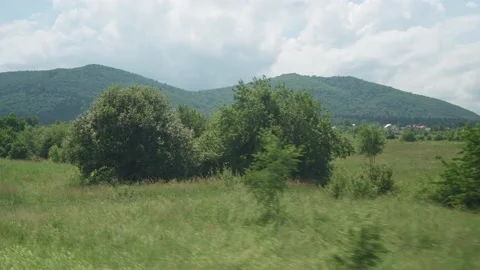 View from window of high-speed train on landscape of beautiful nature wild field Stock Footage 157992477