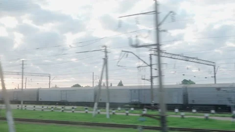 View from window of high-speed train on landscape of old rusty boxcars and high Stock Footage 159622939