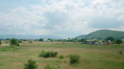 View from window of high-speed train on landscape of beautiful nature wild field Stock Footage 165927041