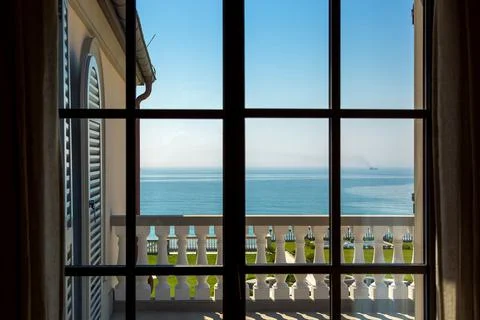 View from the window inside the room on balcony with balustrades and shutters. Stock Photos