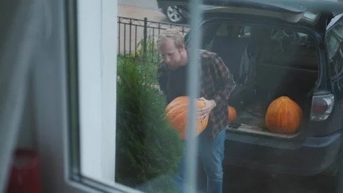 View from the window, a man unloads pumpkins from a car Stock Footage 252046759