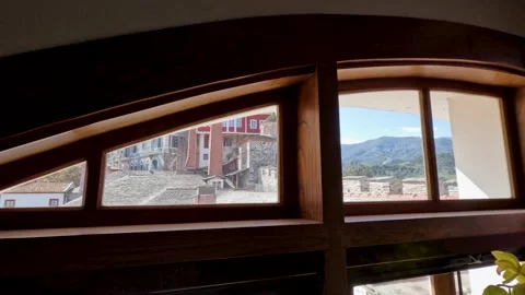 View from a window in a mountain town showing buildings and landscape in Vidéo 333019901