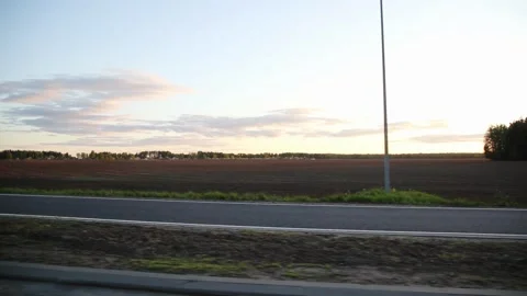 View from the window of a moving car on fields and forests against the backdrop Stock Footage 312596309