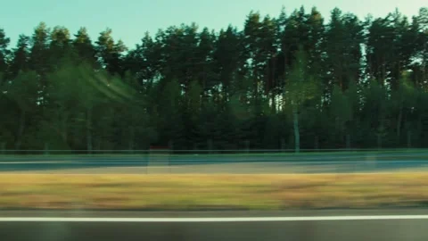 View from window of moving car, motion blur of passing road and green grass, Stock Footage 347579785