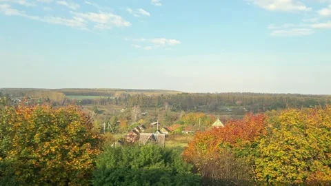 View from the window of moving train to in autumn on rural village houses, trees Stock Footage 252357040