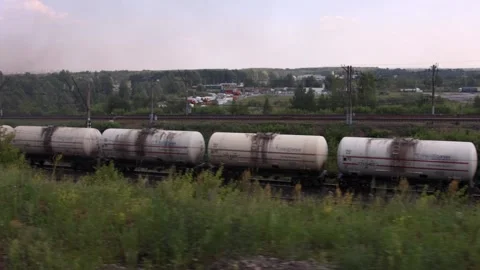 View from the window of a moving train on rails, other trains and nature on a Stock Footage 134945516