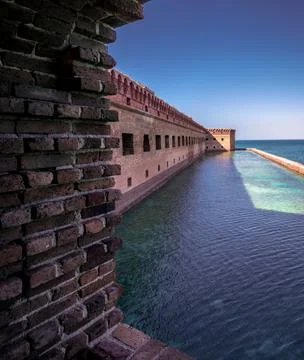 View from the window or casemate of an old brick military fort. Ocean and clear Stock Photos