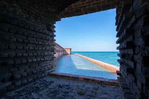 View from the window or casemate of an old brick military fort. Ocean and clear Stock Photos