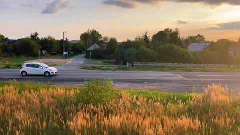 View from the window of a passing train to a village, rural landscape and a car. Stock Footage 318977171