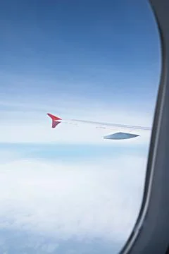 View from window of the plane above expanse of fluffy white clouds Stock Photos