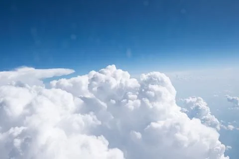 View from window of the plane above expanse of fluffy white clouds Stock Photos