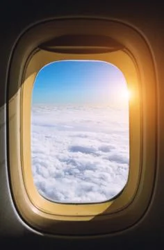 View from the window plane on amazing sky with scenic clouds at the sunset. 库存照片