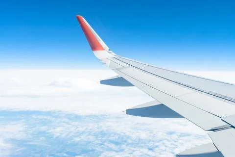 View from the window of the plane on the blue sky, in good weather. Stock Photos