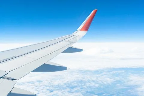 View from the window of the plane on the blue sky, in good weather. Stock Photos
