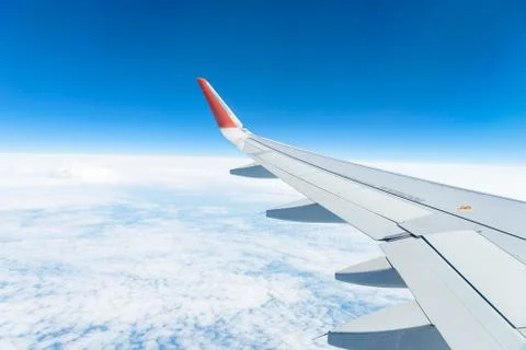 View from the window of the plane on the blue sky, in good weather. Stock Photos
