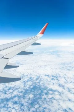 View from the window of the plane on the blue sky, in good weather. Stock Photos