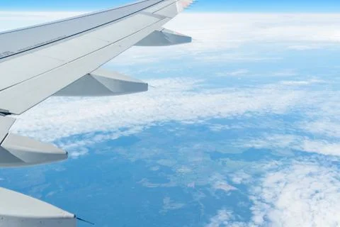 View from the window of the plane on the blue sky, in good weather. Stock Photos