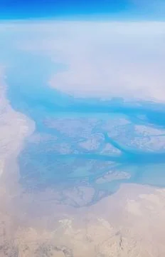 View from the window of plane on blue sky and earth with landscape of desert Stock Photos