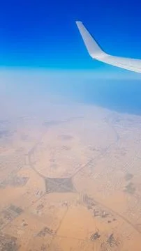 View from the window of plane on blue sky and earth with landscape of desert Stock Photos