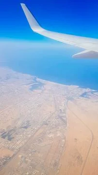 View from the window of plane on blue sky and earth with landscape of desert Stock Photos