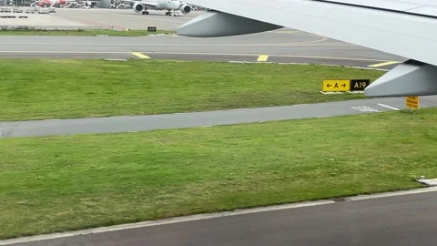 View from window of the plane to the runway markings. Plane goes to runway. Stock Footage 163563083