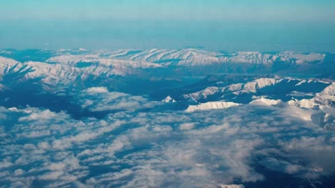 View from the window of the plane to the snowy mountainous area. Stock Footage 329062624